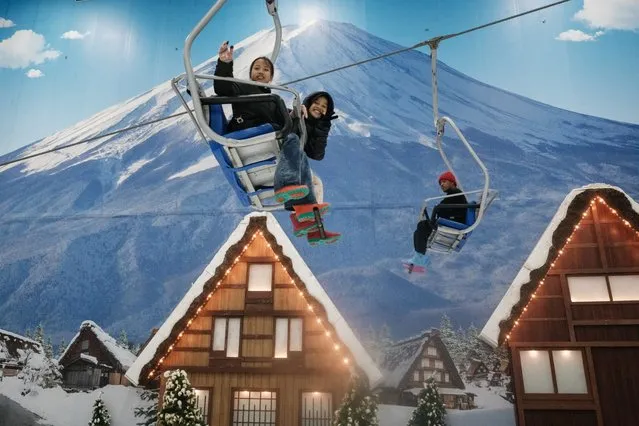 People ride on ski lifts at Trans Snow World Bintaro, an indoor snow park with a Japanese theme, in Bintaro on December 27, 2023. (Photo by Yasuyoshi Chiba/AFP Photo)