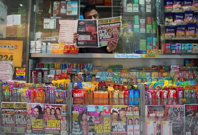 A newspaper vendor on Third Avenue in midtown New York City displays a copy of the National Enquirer for a photographer at his newstand February 8, 2019. The publisher of the National Enquirer said Friday, February 8, 2019 it would open an internal probe of accusations by Amazon's Jeff Bezos over blackmail and extortion by the supermarket tabloid. Bezos, who publishes The Washington Post, said the Enquirer tabloid's parent company had threatened him if he did not halt his investigation into the motives behind the leak of intimate photos he sent to his mistress. (Photo by Timothy A. Clary/AFP Photo)