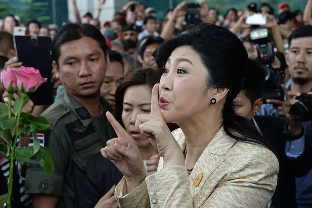 Deposed former Thai prime minister Yingluck Shinawatra gestures as she arrives for a hearing at the supreme court in Bangkok on March 4, 2016. Yingluck appeared at court for a negligence trial that could see her in prison for a decade, turning a spotlight on the popular leader amid signs that her family's political machine is lurching back to life. Yingluck was removed from office by a court days before army chief Prayut Chan-O-Cha staged a coup in May 2014 and installed a military government still in power. (Photo by Christophe Archambault/AFP Photo)