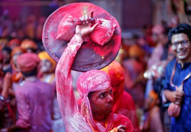 A man daubed in colours holds a shield during “Lathmar Holi” celebrations inside a temple in the town of Barsana, in Uttar Pradesh, India, March 15, 2019. (Photo by Altaf Hussain/Reuters)