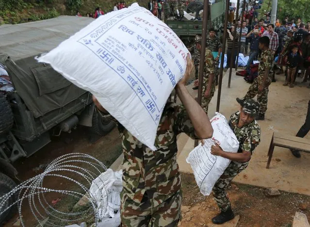 Nepalese soldiers carry goods to an army helicopter to supply remote areas by air near the epi-centre of Saturday's earthquake in Gorkha, Nepal, April 29, 2015. (Photo by Wolfgang Rattay/Reuters)
