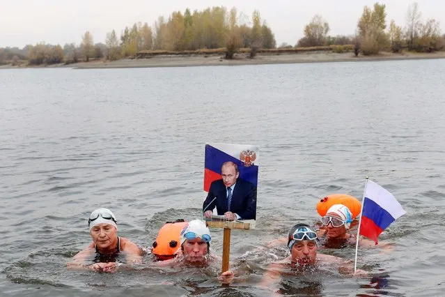 Members of a local winter swimming club take part in an event marking the 69th birthday of Russian President Vladimir Putin in the waters of the Ob River in Barnaul, Russia on October 7, 2021. (Photo by Andrei Kasprishin/Reuters)