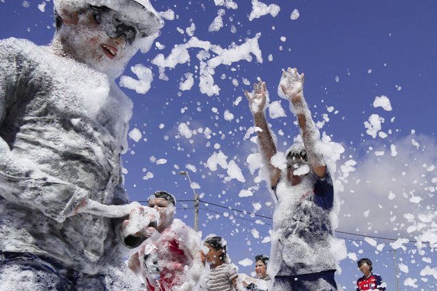 Children play on a court blanketed with soap foam, during a summer activity in Tongoy, Chile, Thursday, January 25, 2024. (Photo by Matias Basualdo/AP Photo)