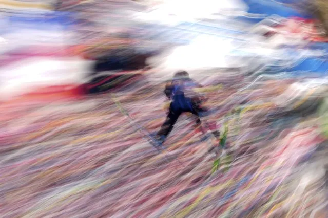 In this picture taken with a slow shutter speed, Karl Geiger, of Germany, soars through the air during his first round jump of the Men Team competition at the ski flying world championships, at the Kulmkogel mountain in Bad Mitterndorf, Austria, Sunday, January 28, 2024. (Photo by Matthias Schrader/AP Photo)