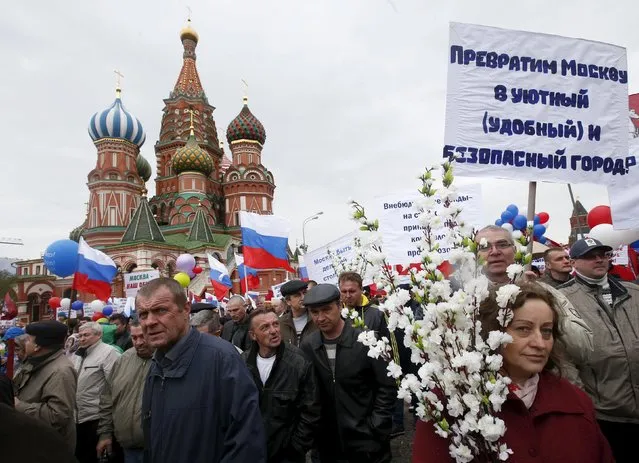 People walk with flags and banners at Red Square during a May Day rally in Moscow May 1, 2015. The placard reads, “Let's turn Moscow into a comfortable and safe city”. (Photo by Maxim Zmeyev/Reuters)