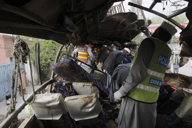 Pakistani security personnel examine a bus following a bomb blast in Peshawar, Pakistan, Wednesday, March 16, 2016. (Photo by Mohammad Sajjad/AP Photo)