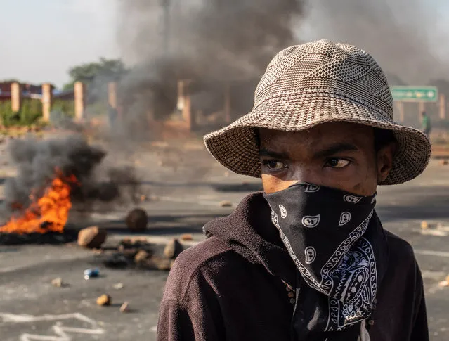A protestor covers his face with a bandana while he and others occupy the junction of a busy road as part of a service delivery protest in Eldorado Park, Johannesburg, South Africa, 15 April 2019. Reports state that the residents of the area protested over poor service delivery and demanded new housing. The ongoing service delivery issue is a major challenge for the ruling ANC as the country goes to the polls on 08 May 2019 for elections in the country. (Photo by Kim Ludbrook/EPA/EFE)