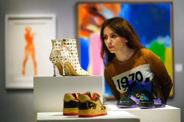 A Bonhams gallery assistant looks at Spot boots, 2002, created by Damian Hirst for Manolo Blahnik, estimated to fetch 2,000 to 3,000, as part of Bonhams' forthcoming Pop x Culture Sale at their London auction house on Monday, November 8, 2021. (Photo by Victoria Jones/PA Images via Getty Images)