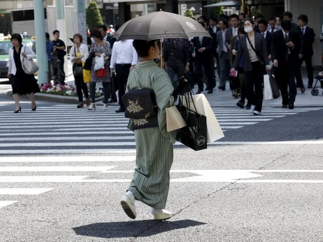 A woman in a traditional “Kimono” carries shopping bags at a shopping district in Tokyo in this May 19, 2011 file photo. (Photo by Kim Kyung-Hoon/Reuters)