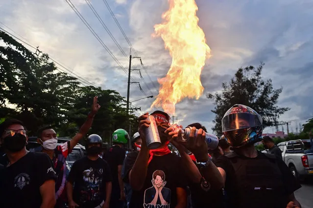 Protesters create flames by lighting up aerosol cans during a demonstration against the government of Thailand's Prime Minister Prayut Chan-O-Cha and in support of the release of political prisoners outside Bangkok Remand Prison in Bangkok on October 13, 2021. (Photo by Lillian Suwanrumpha/AFP Photo)