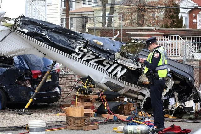 An official surveys the scene where a small plane crash landed on a residential street in Bayonne, New Jersey, U.S. February 19, 2017. (Photo by Ashlee Espinal/Reuters)