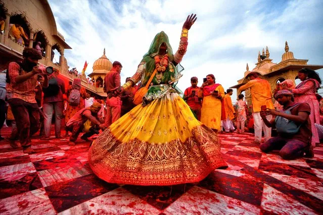 A transgender woman dances during the Laddu Holi celebrations at the Radharani temple of Barssana – Uttar Prades in Mathurah on March 17, 2024. The spring festival of colours at Radharani temple in Barsana village of India's Uttar Pradesh is the first day of Celebration of the main Holi Festival. This festival the devotees and priests of Barsana Temple throw Laddu (Traditional Sweet) on each other. Holi is a spring festival also known as the festival of colours or the festival of love. (Photo by Avishek Das/SOPA Images/Rex Features/Shutterstock)