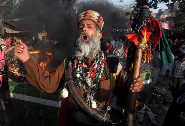 A Sufi devotee shouts religious slogans while he dances at the shrine of Madhu Lal Shah Hussain, a poet also regarded as a Sufi saint, during an annual festival to celebrate him in Lahore, Pakistan, Saturday, March 26, 2016. The annual festival to commemorate Shah Hussain (1538-1599) started on Saturday with thousands of people expected to visit the shrine. (Photo by K.M Chaudary/AP Photo)