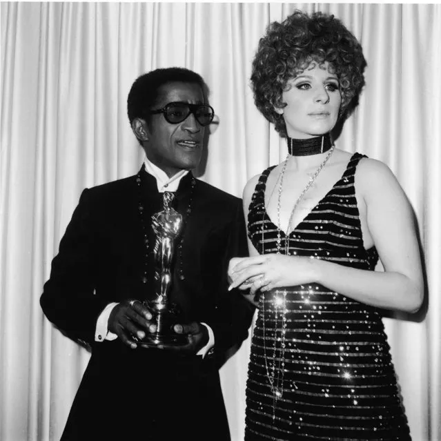 American singer and actor Sammy Davis Jr. (1925 – 1990) stands with presenter Barbra Streisand, holding the Oscar for Best Song, at the Academy Awards ceremony, Santa Monica Civic Auditorium, Santa Monica, California, April 10, 1968. Davis accepted the Oscar on behalf of Leslie Bricusse, for the song “Talk to The Animals” from the film “Doctor Dolittle”. (Photo by Fotos International/Getty Images) 