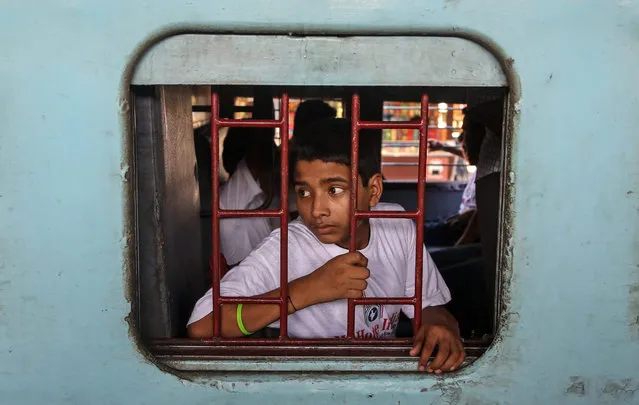 An Indian youth sits in a special chartered train bound for Patna, at the Bandra railway station in Mumbai, India, 18 May 2015. He is one of a group, consisting of 20 child laborers and nine missing children, which were rescued by the NGO “My Home India” and Indian police forces in raids against employers ignoring a nationwide ban on child labour. (Photo by Divyakant Solanki/EPA)