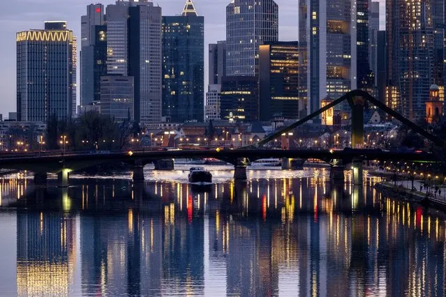 The buildings of the banking district are reflected in the river Main in Frankfurt, Germany, Sunday, March 17, 2024. (Photo by Michael Probst/AP Photo)