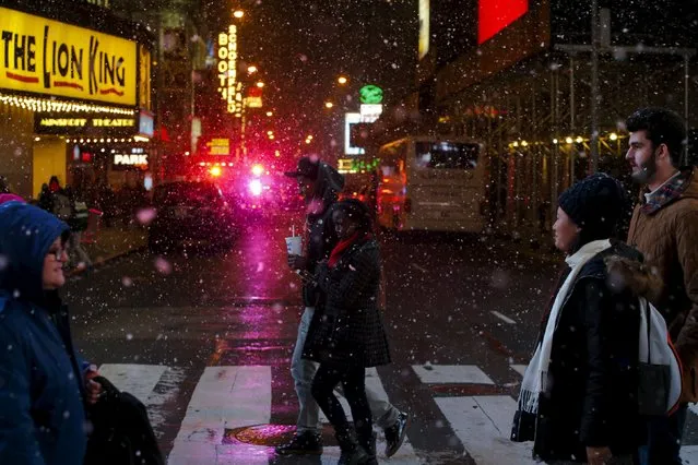 People walk in Times Square as snow falls down during the first day of spring in New York, March 20, 2016. (Photo by Eduardo Munoz/Reuters)