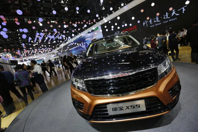Visitors tour near the Chinese automaker BAIC X55 SUV on display at the Beijing International Automotive Exhibition in Beijing, Monday, April 25, 2016. (Photo by Andy Wong/AP Photo)
