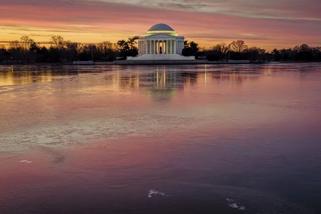 Sunrise reflects off of the frozen surface of the Tidal Basin in front of the Jefferson Memorial on a chilly start to the day in Washington, Sunday, January 23, 2022. (Photo by J. David Ake/AP Photo)