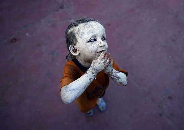 A girl with her body covered with Multani Mitti or Fuller's earth is seen at a marketplace in the old quarters of Delhi June 19, 2015. (Photo by Anindito Mukherjee/Reuters)