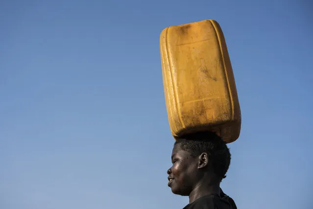 In this photo taken Wednesday, March 8, 2017, a young girl carries clean water home from a water treatment point built by UNICEF in Torit, South Sudan. (Photo by Mackenzie Knowles-Coursin/UNICEF via AP Photo)