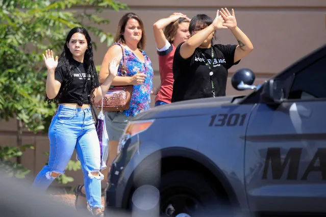 Shoppers exit with their hands up after a mass shooting at a Walmart in El Paso, Texas, U.S. on August 3, 2019. Multiple people were killed and one person was in custody after a shooter went on a rampage at a shopping mall, police in the Texas border town of El Paso said. (Photo by Jorge Salgado/Reuters)