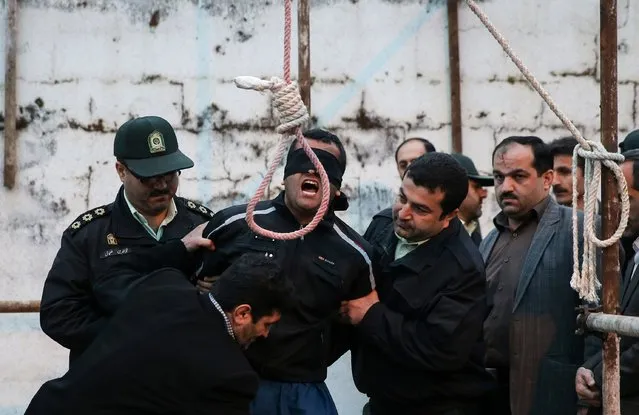 Balal, who killed Iranian youth Abdolah Hosseinzadeh in a street fight with a knife in 2007, is brought to the gallows during his execution ceremony in the northern city of Nowshahr on April 15, 2014. The mother of  Abdolah Hosseinzadeh spared the life of the her son's convicted murderer, with an emotional slap in the face as he awaited execution prior to removing the noose around his neck. (Photo by Araash Khamooshi/AFP Photo/ISNA)