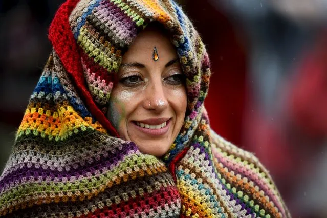 A reveller smiles as she walks in the rain at Worthy Farm in Somerset during the Glastonbury Festival in Britain, June 28, 2015. (Photo by Dylan Martinez/Reuters)