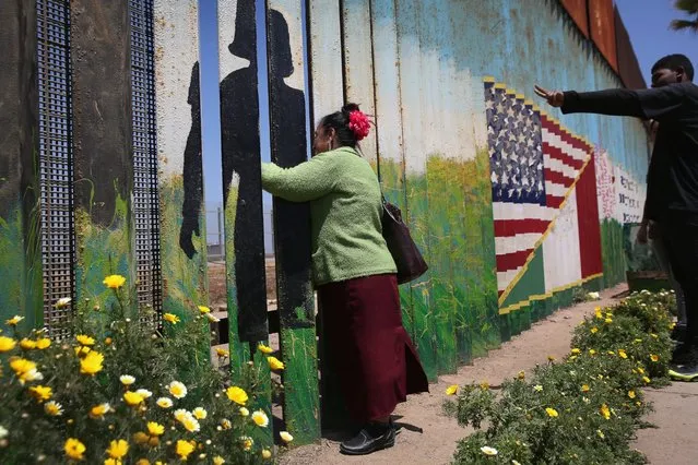 Juana Medina waves to her daughter and grandchildren through the U.S.-Mexico border fence on May 1, 2016 in Tijuana, Mexico. Medina said her daughter immigrated from Mexico to Tennessee 20 years ago and brought her two children back to the border fence in Tijuana to see their grandmother for the first time. Mexicans on the Tijuana side can approach the border fence, painted with colorful murals, at any time. The U.S. Border Patrol, however, tightly controls the San Diego, CA side and allows visitors to speak to loved ones through the fence during restricted weekend hours at “Friendship Park”. (Photo by John Moore/Getty Images)