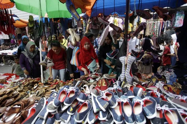 Indonesian Muslim women buy shoes at a market in Jakarta, Indonesia, Friday, July 10, 2015. Markets and shopping malls in the capital of the world's most populous Muslim country are expected to be crowded with people shopping for the celebration on July 17 which marks the end of the holy fasting month of Ramadan. (Photo by Achmad Ibrahim/AP Photo)