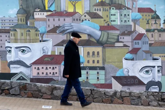 A man walks past part of a large street mural on February 15, 2022 in Kyiv, Ukraine.  (Photo by Chris McGrath/Getty Images)
