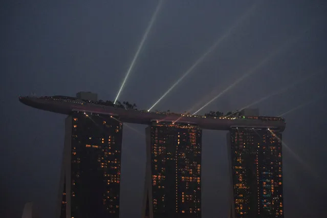 A laser light show plays from the top of the Marina Bay Sands integrated resort during haze in Singapore, September 18, 2019. (Photo by Kevin Lam/Reuters)