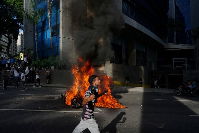 A police motorbike burns as people protest following the announcement by the National Electoral Council that Venezuela's President Nicolas Maduro won the presidential election, in Caracas, Venezuela on July 29, 2024. (Photo by Alexandre Meneghini/Reuters)