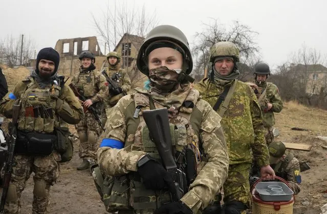Ukrainian soldiers smile as they have a rest in Irpin close to Kyiv Friday, April 1, 2022. The more than month-old war has killed thousands and driven more than 10 million Ukrainians from their homes including almost 4 million from their country. (Photo by Efrem Lukatsky/AP Photo)