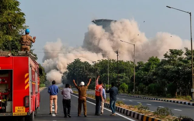 Rescue workers react as the second of India's highest 118-meter twin cooling towers of Gujarat State Thermal Power Station starts to collapse on the outskirts of Gandhinagar some 40 kms from Ahmedabad on December 1, 2019. (Photo by Sam Panthaky/AFP Photo)