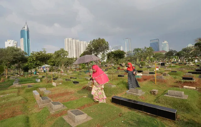 People walk through a cemetary while visiting the graves of loved ones ahead of the Muslim fasting month of Ramadan in Jakarta, Indonesia June 4, 2016 in this photo taken by Antara Foto. (Photo by Yudhi Mahatma/Reuters/Antara Foto)