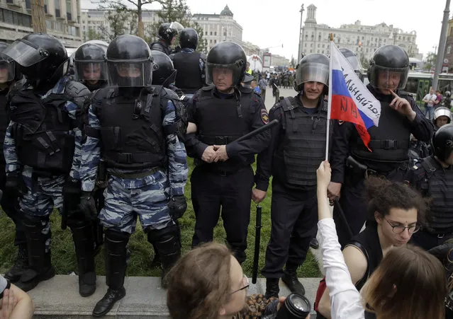 Police watch the scene during a demonstration in downtown Moscow, Russia, Monday, June 12, 2017. (Photo by Pavel Golovkin/AP Photo)