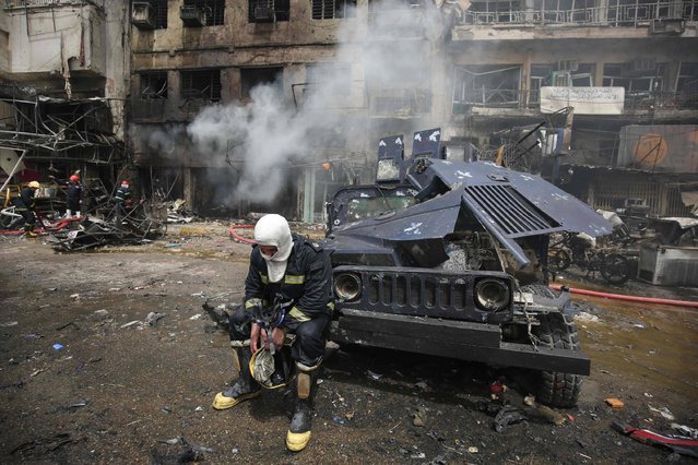 An Iraqi fireman sits after fire was extinguished at the site of car bomb attack in the mostly Shiite neighbourhood of Baghdad Jadida in the Iraqi capital on June 9, 2016. A suicide car bomb attack near a military base north of Baghdad and another blast near a market in the Iraqi capital killed at least 18 people, police said. (Photo by Ahmad Al-Rubaye/AFP Photo)