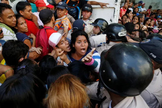 People gather to try to buy pasta while riot police try to control the crowd outside a supermarket in Caracas, Venezuela, June 10, 2016. (Photo by Carlos Garcia Rawlins/Reuters)