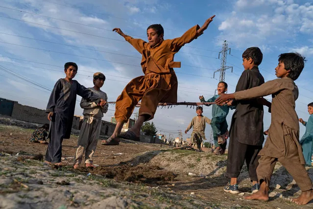 Afghan children play in a field in Kabul on April 28, 2022. (Photo by Wakil Kohsar/AFP Photo)