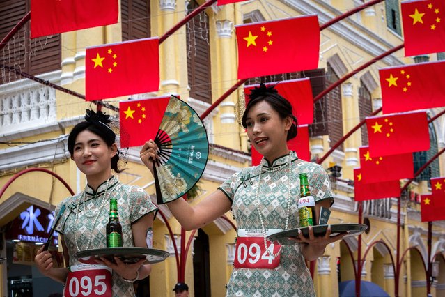 Contestants finsh the tray race at the Leal Senado square during the tray race to celebrate the World Tourism Day in Macau on September 27, 2024. (Photo by Eduardo Leal/AFP Photo)