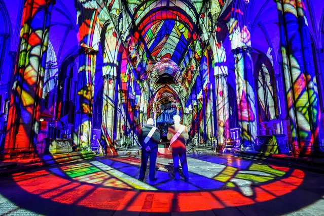 Ushers admire the interior of Salisbury Cathedral on February 18, 2020, where a light and sound art installation, titled Sarum Lights, is marking the Cathedral's 800th anniversary in 2020, by lighting the inside and outside along with music. (Photo by Ben Birchall/PA Images via Getty Images)