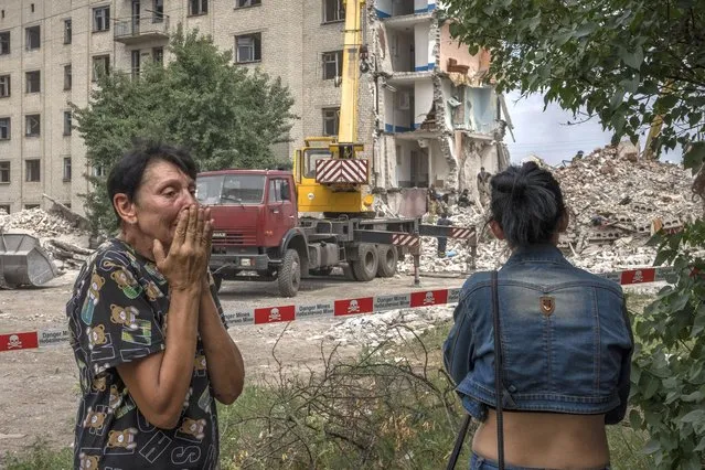 Iryna Shulimova, 59, weeps at the scene in the aftermath of a Russian rocket that hit an apartment residential block, in Chasiv Yar, Donetsk region, eastern Ukraine, Sunday, July 10, 2022. At least 15 people were killed and more than 20 people may still be trapped in the rubble, officials said Sunday. (Photo by Nariman El-Mofty/AP Photo)
