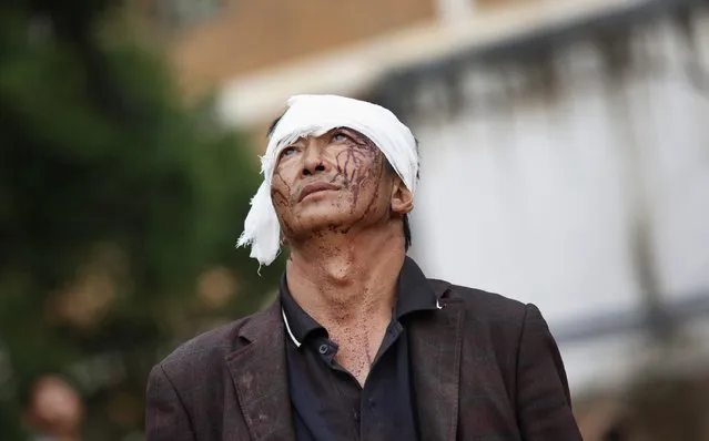 An injured man looks up as he walks next to debris after an earthquake hit Ludian county, Yunnan province August 4, 2014. A magnitude 6.5 earthquake struck southwestern China on Sunday, killing at least 398 people in a remote area of Yunnan province, and causing thousands of buildings, including a school, to collapse, Xinhua News Agency reported. (Photo by Reuters/China Daily)