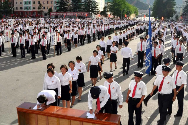 This picture taken on August 10, 2017 and released by North Korea's official Korean Central News Agency (KCNA) on August 13, 2017 shows North Korean working youth and university students queueing to sign petitions to join or rejoin the Korean People's Army after the UN Security Council's “sanctions resolution”. (Photo by AFP Photo/KCNA)