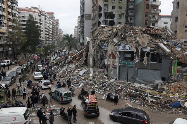 People gather as cars drive past rubble from damaged buildings in Beirut's southern suburbs, after a ceasefire between Israel and Iran-backed group Hezbollah took effect at 0200 GMT on Wednesday after U.S. President Joe Biden said both sides accepted an agreement brokered by the United States and France, in Lebanon, on November 27, 2024. (Photo by Mohamed Azakir/Reuters)