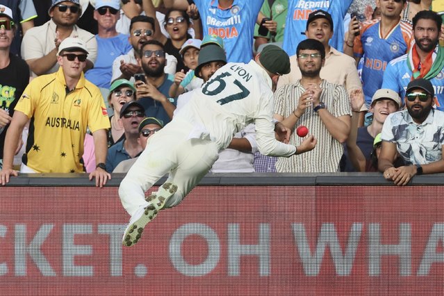 Australia's Nathan Lyon leaps to take a catch of India's Nitish Kumar Reddy during the day one of the second cricket test match between Australia and India at the Adelaide Oval in Adelaide, Australia, Friday, December 6, 2024. (Photo by James Elsby/AP Photo)