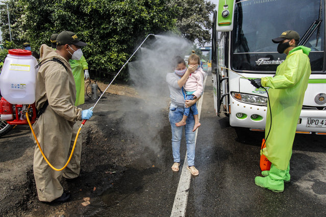 National Police members disinfect Venezuelan citizens returning to the country from Colombia, as a preventive measure against the spread of the coronavirus –COVID19- at the Simon Boliviar International Bridge, in Cucuta, Colombia-Venezuela border, on April 4, 2020. Since the first case of COVID-19 was detected last March 6, Colombia has reported 1,406 people infected and 32 dead. (Photo by Schneyder Mendoza/AFP Photo)