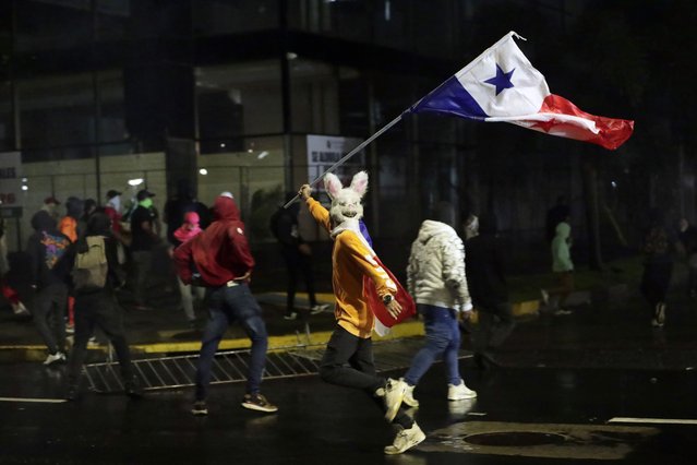 A protester runs amid clashes with police during a march against copper mining in Panama City, Panama, 28 October 2023. Protests continue in Panama after the renewal of a concession to Minera Panama, a subsidiary of Canadian First Quantum Minerals, which operates the largest open-pit copper mine in Central America. (Photo by Bienvenido Velasco/EPA)