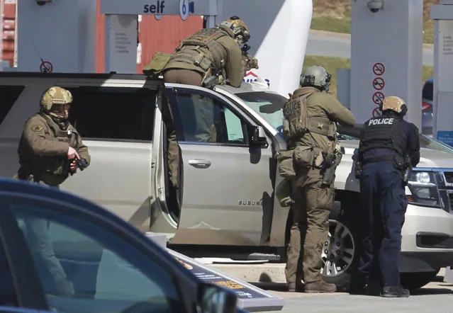 Royal Canadian Mounted Police officers surround a suspect at a gas station in Enfield, Nova Scotia, Sunday April 19, 2020. Canadian police say multiple people are dead plus the suspect after a shooting rampage across the province of Nova Scotia. It was the deadliest shooting in Canada in 30 years. (Photo by Tim Krochak/The Canadian Press via AP Photo)